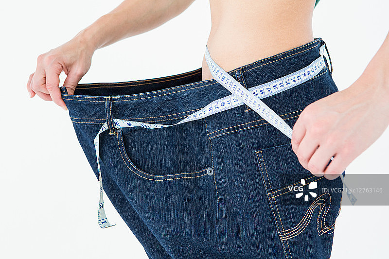 在白色背景下，腰围减小很多的女人图片素材