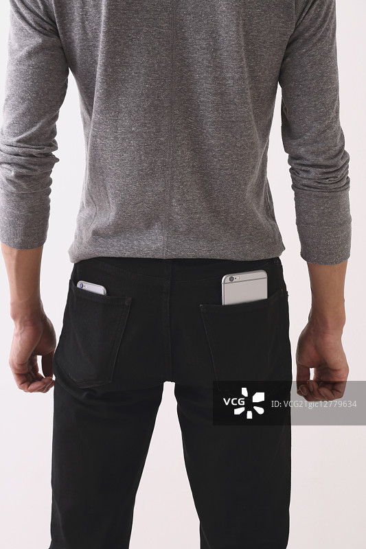 口袋里装着智能手机的年轻男人图片素材