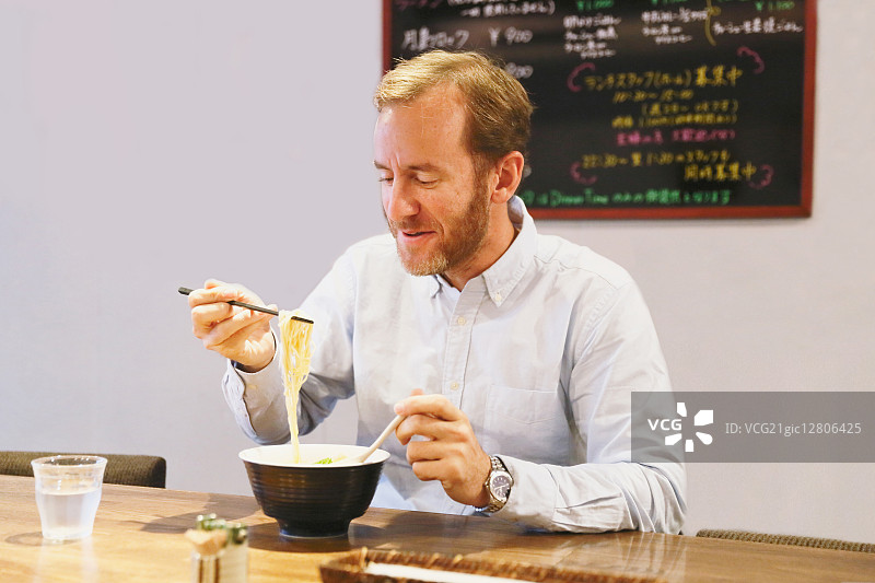 吃拉面的白人男子图片素材