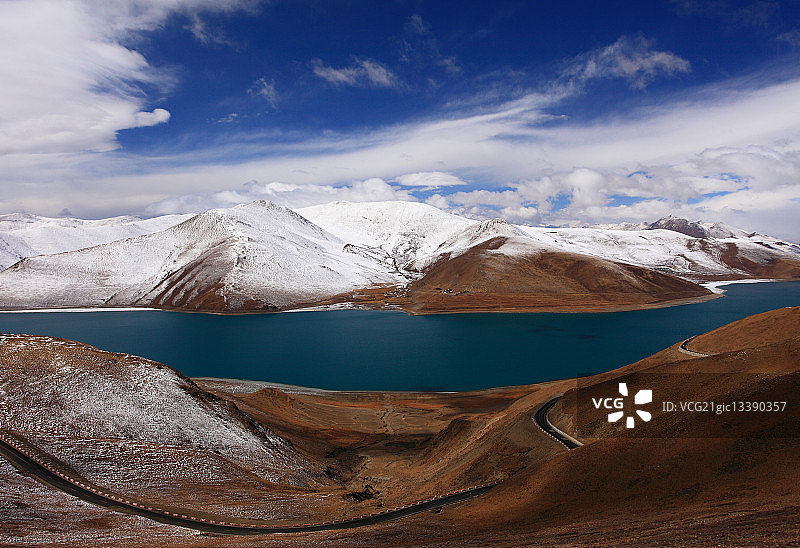 山南藏族聚居区，羊卓雍错湖，棕色雪山环绕，多云图片素材