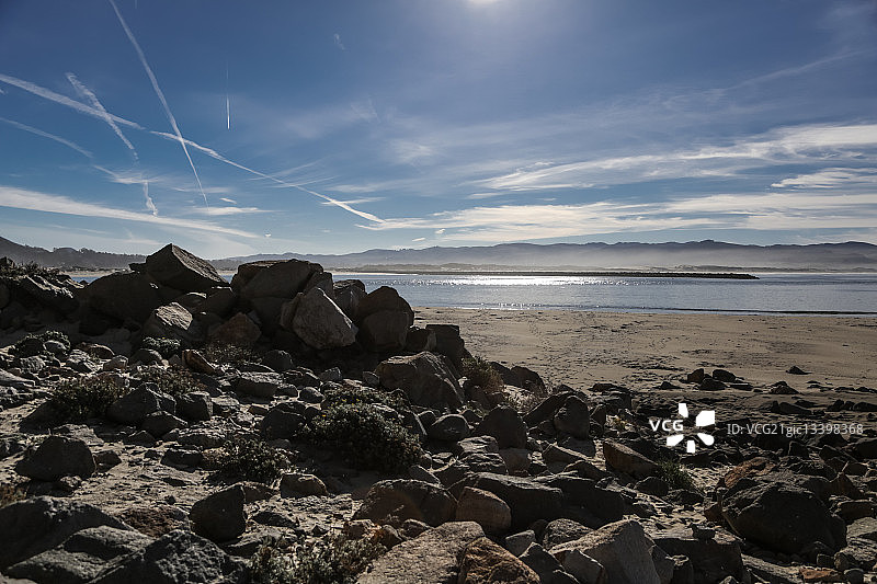 莫罗湾岩石海滩与天空中的飞机尾迹，美国加利福尼亚州图片素材