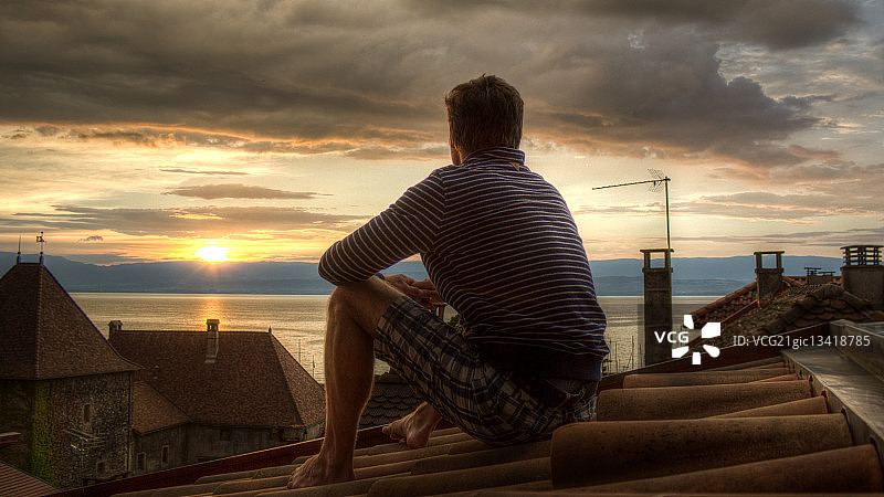 在法国日内瓦湖边看日落的男人图片素材