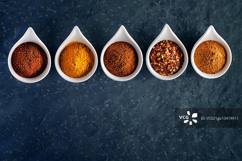 深色石板上勺子里的香料图片素材