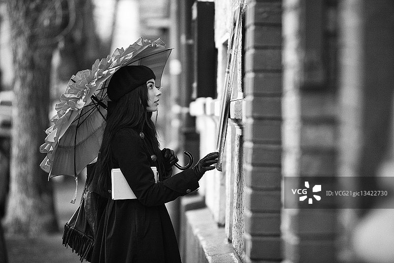 在罗马尼亚布加勒斯特，穿着保暖服装拿着雨伞的女人图片素材