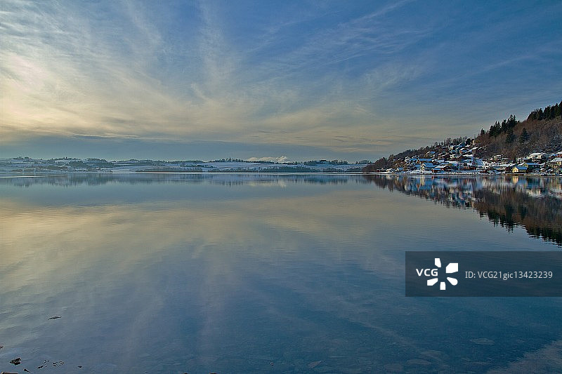 挪威Nord-Trondelag郡Levanger平静的湖面反射出多云的天空图片素材