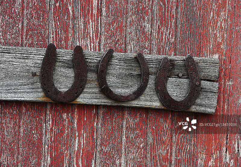 挂在风化墙上的生锈马蹄铁图片素材
