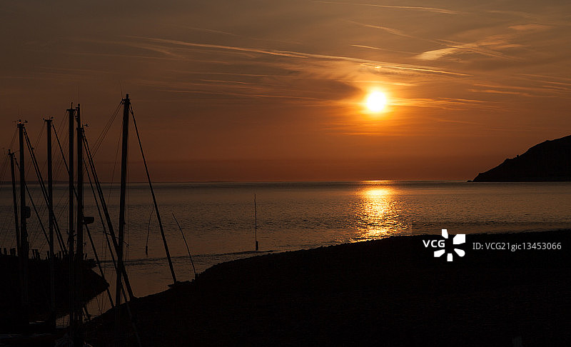 英国萨默塞特郡埃克斯穆尔国家公园波洛克威尔海边日落与帆船剪影图片素材