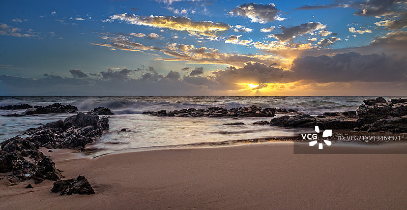 阴天日落时的岩石海滩图片素材