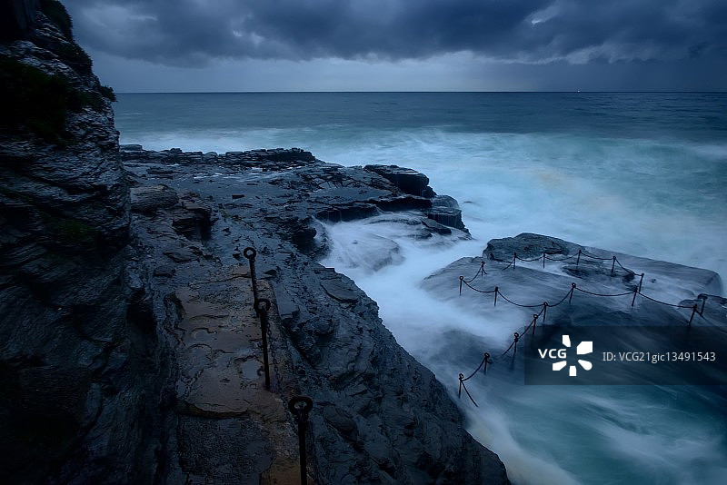 澳大利亚新南威尔士州纽卡斯尔的岩石海岸上雷暴和海浪图片素材