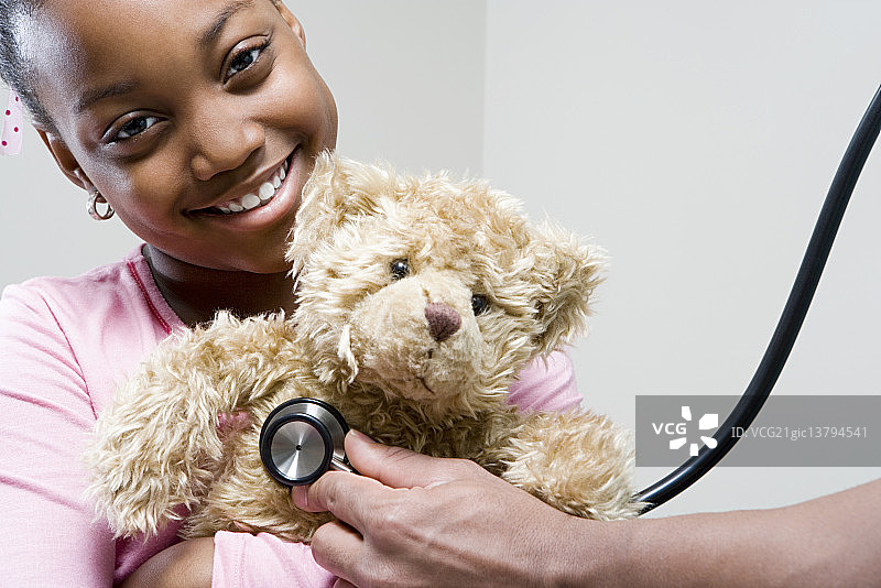 女孩和带听诊器的泰迪熊图片素材