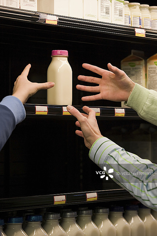 人们伸手去拿牛奶图片素材