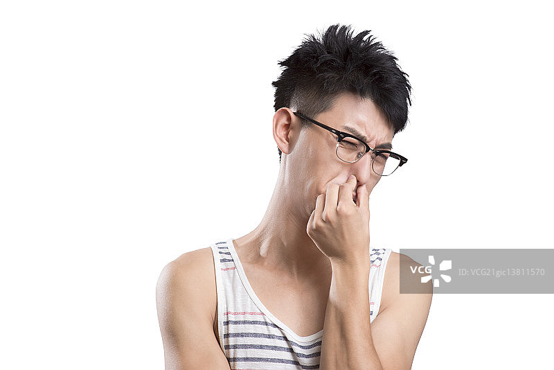 Portrait of young man holding nose图片素材