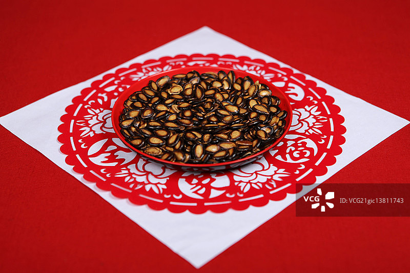 红色福字剪纸上的一碟西瓜子图片素材