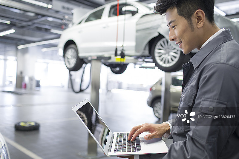 汽车修理工使用笔记本电脑图片素材