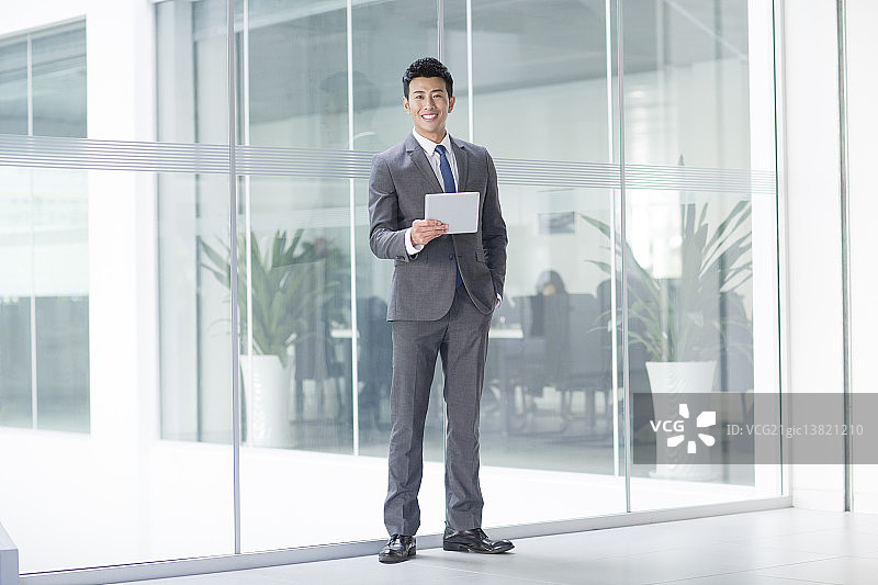 年轻商务男士拿着平板电脑图片素材