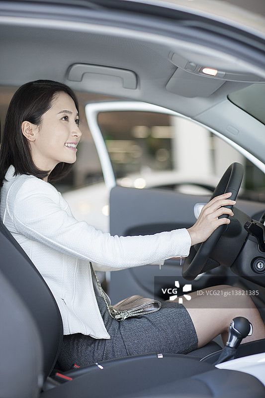 年轻女子在4S店选购汽车图片素材