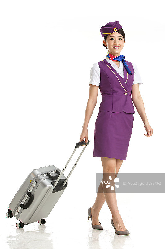 青年女乘务员拉着行李箱图片素材