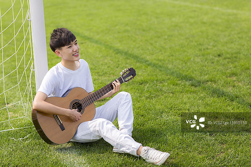坐着弹吉他的男学生图片素材