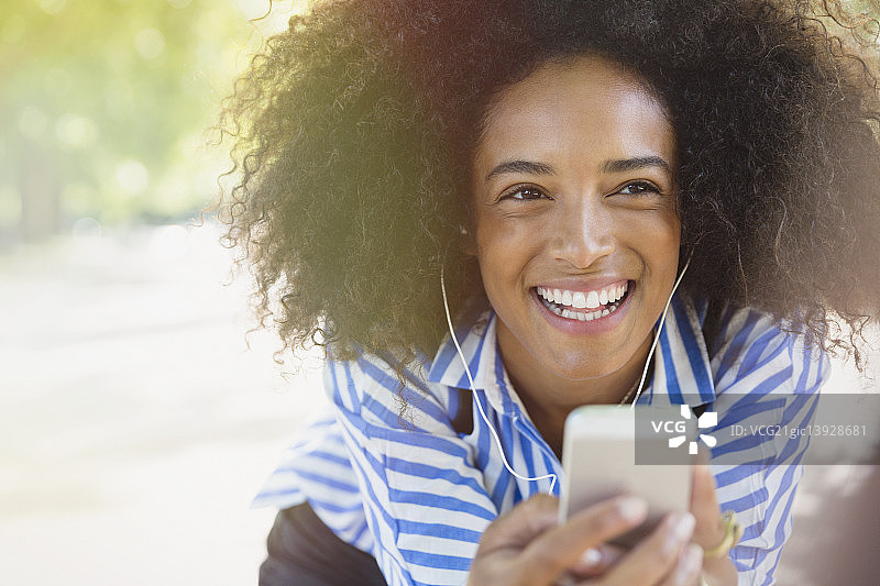 戴耳机用MP3播放器听音乐的女士图片素材