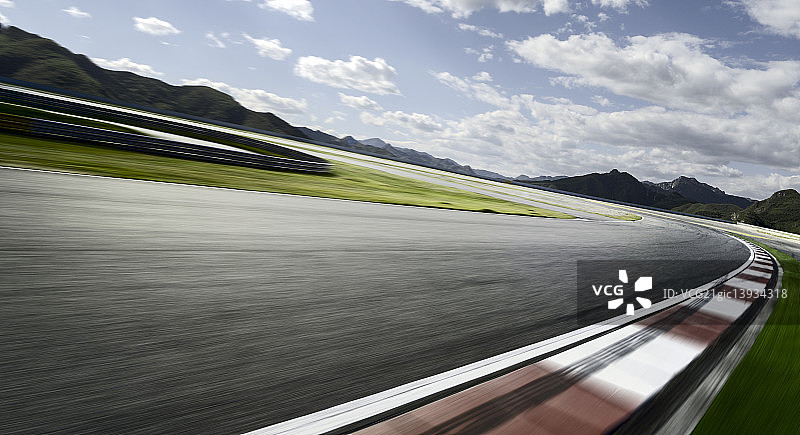 远山背景的F1赛道运动模糊速度特效图片素材