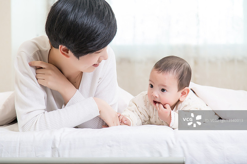 宝宝和妈妈在床上玩耍图片素材