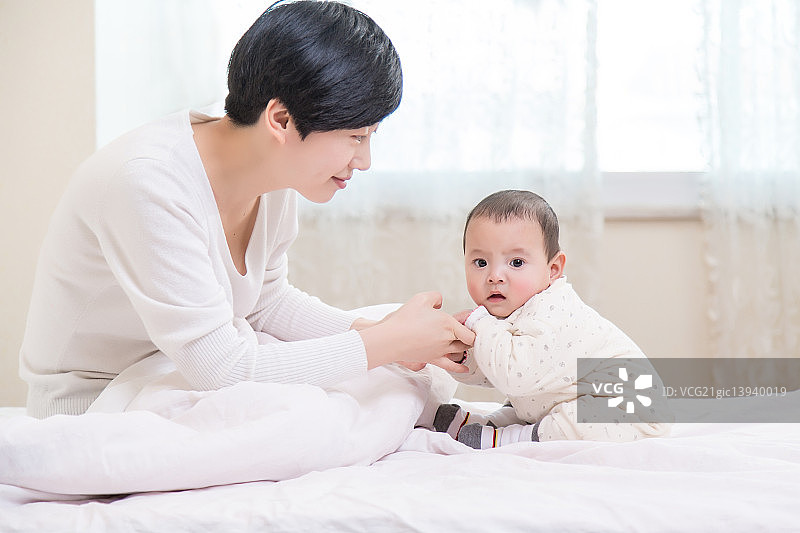 宝宝和妈妈在床上玩耍图片素材