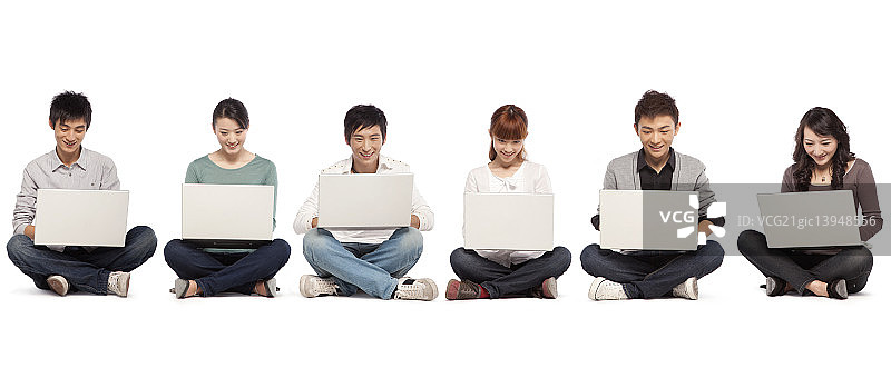六名年轻人排成一排使用笔记本电脑图片素材