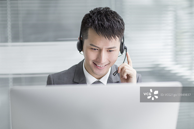 商务男士戴着耳麦工作图片素材