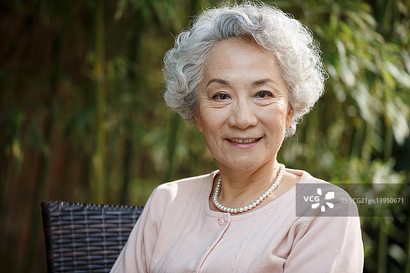 休闲的老年女人坐在院子里图片素材