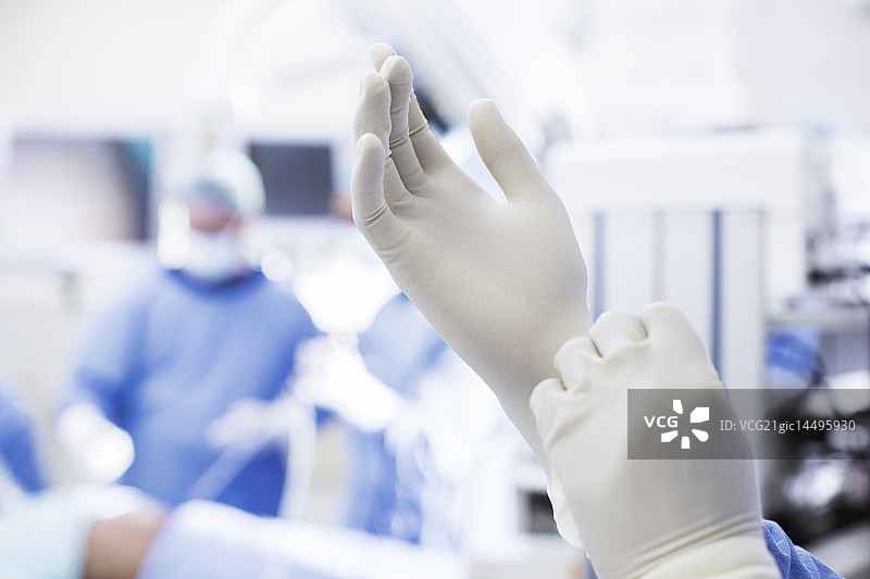 外科医生在手术室戴外科手套的特写图片素材
