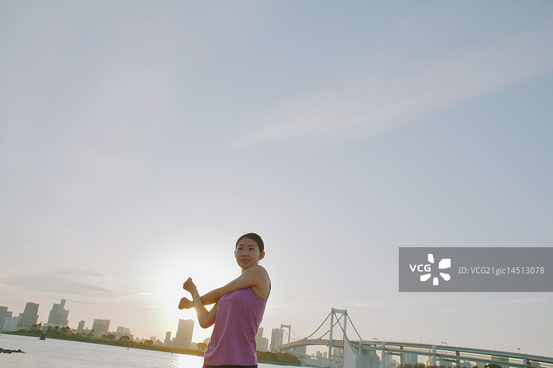 在东京闹市区跑步前伸展身体的年轻日本女子图片素材