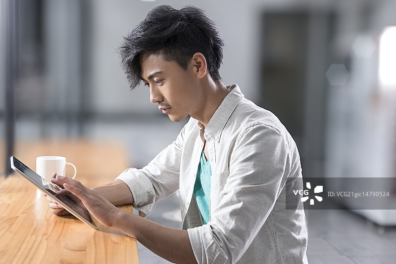 Creative businessman using digital tablet in break room图片素材