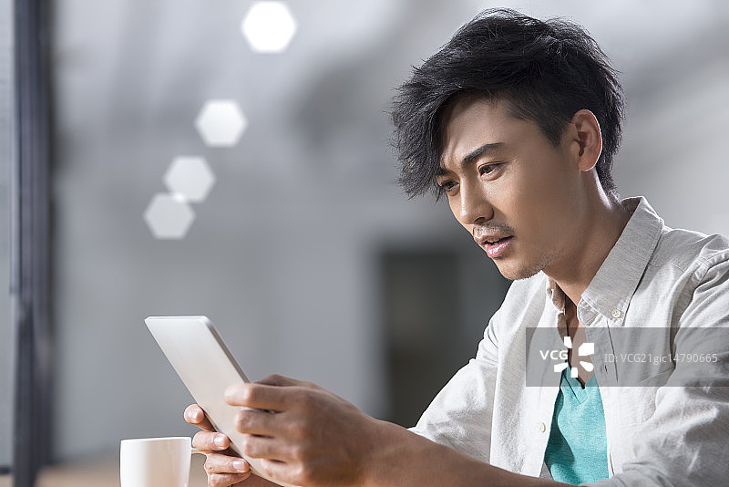 Creative businessman using digital tablet in break room图片素材