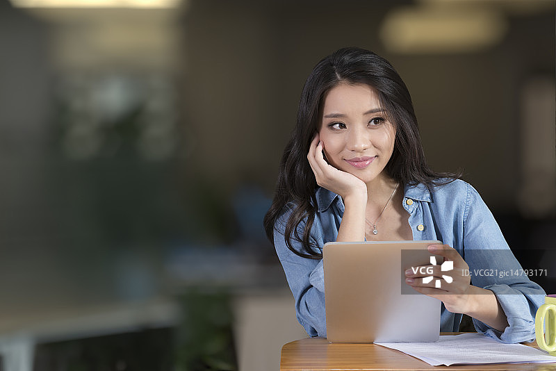 Creative businesswoman using digital tablet in break room图片素材