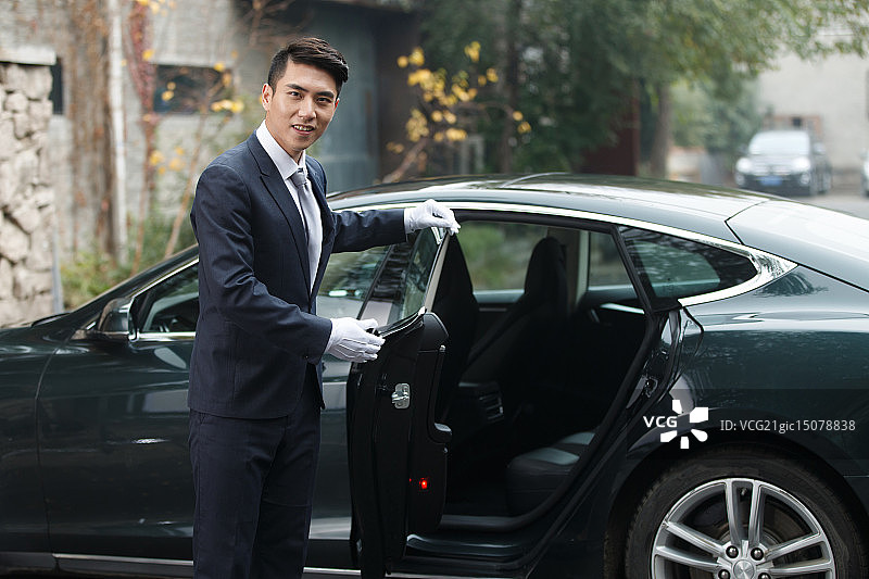 年轻的男招待打开车门图片素材