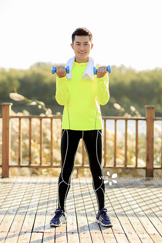 青年男人在户外做哑铃操图片素材