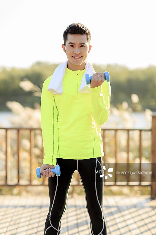 青年男人在户外做哑铃操图片素材