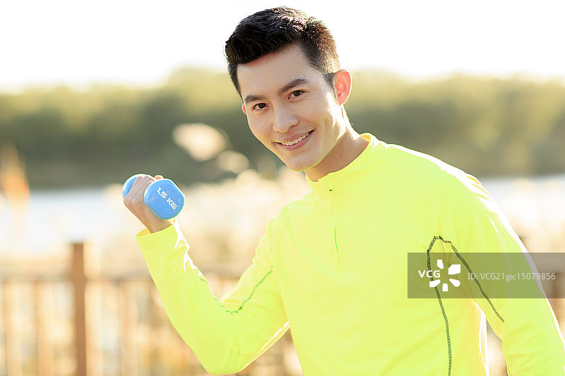 青年男人在户外做哑铃操图片素材