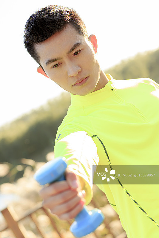青年男人在户外做哑铃操图片素材