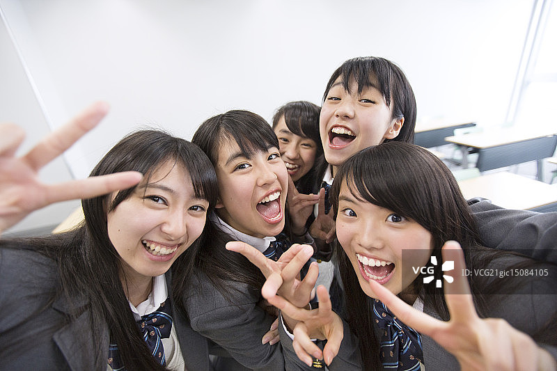 在教室里做出胜利手势的高中女生图片素材