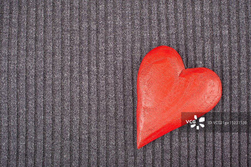 针织背景上的红色木制心形图片素材
