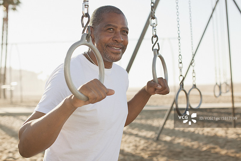 年长的男人在海滩上拿着健身圈图片素材