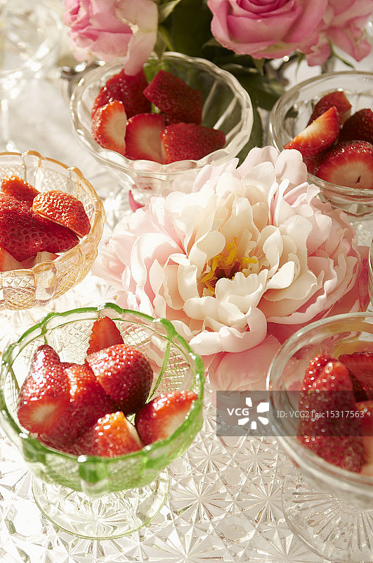 桌上的碗装草莓和鲜花图片素材