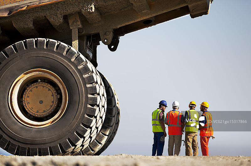 工人在现场机械旁交谈图片素材