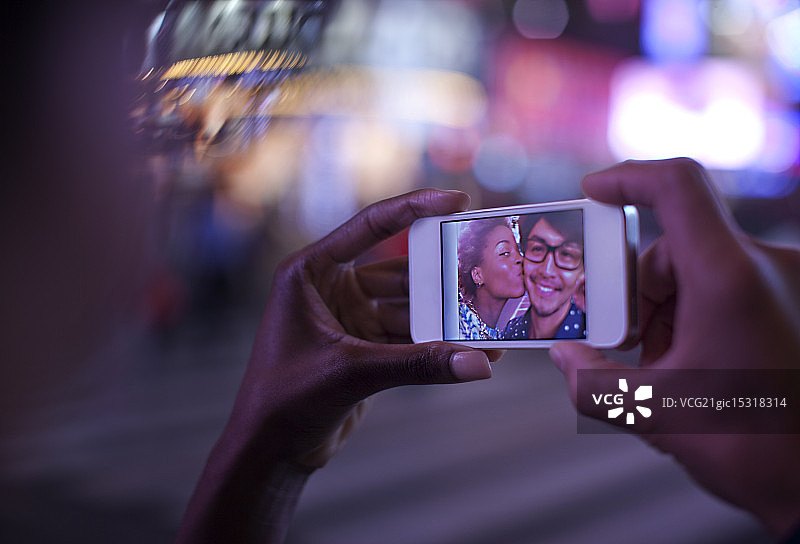 女人手持屏幕上有照片的手机图片素材