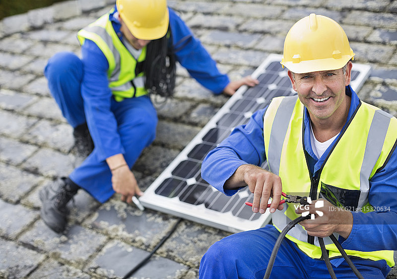 工人在屋顶安装太阳能电池板图片素材