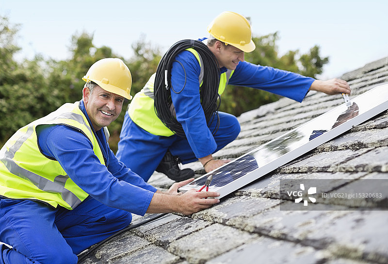 工人在屋顶安装太阳能电池板图片素材