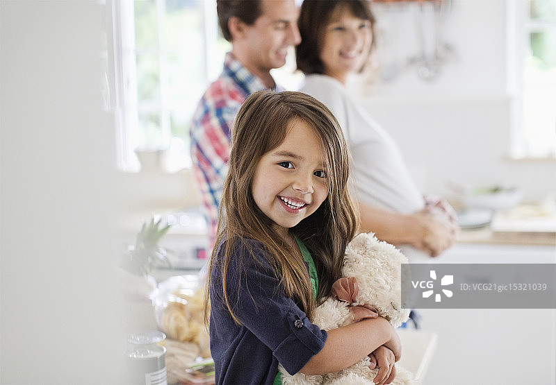 在厨房里抱着泰迪熊的女孩图片素材