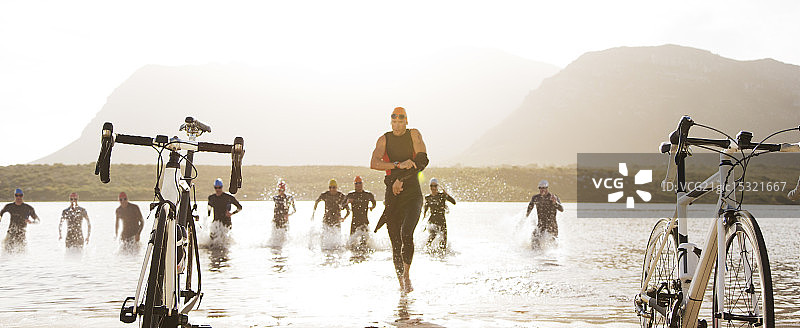 沙滩上铁人三项运动员跑向自行车图片素材