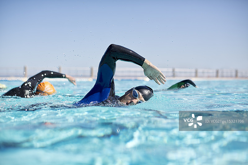 穿着潜水衣的铁人三项运动员在泳池中比赛图片素材
